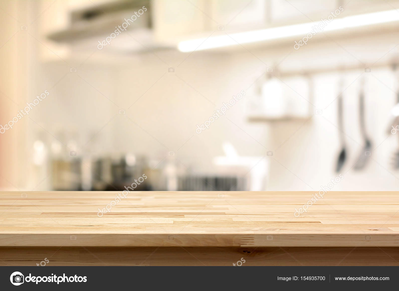 Wood table top (as kitchen island) on blur kitchen interior background
