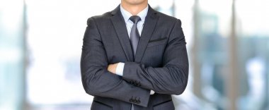 Kollarını geçerken koyu gri elbiseli anonim işadamı