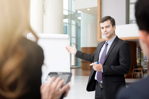 Jonge zakenman als een leider van de vergadering presenteren van werk — Stockfoto