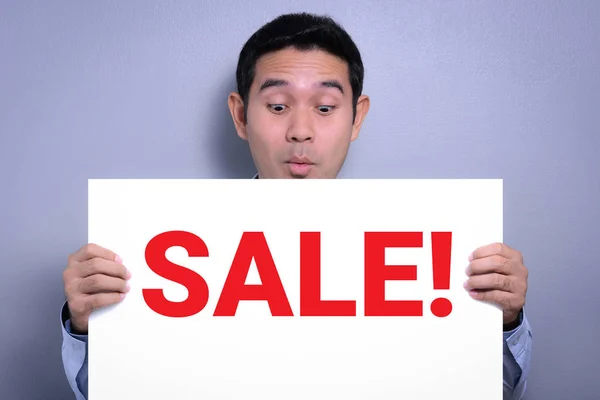 A man with excited face showing SALE! sign — Stock Photo, Image
