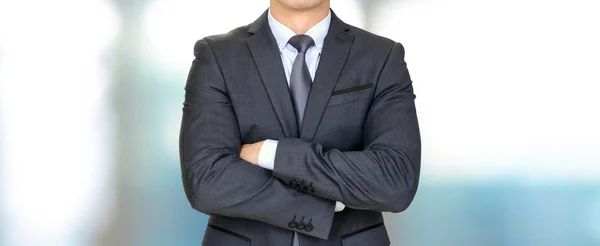 Anonymous businessman in dark gray suit crossing his arms — Stock Photo, Image