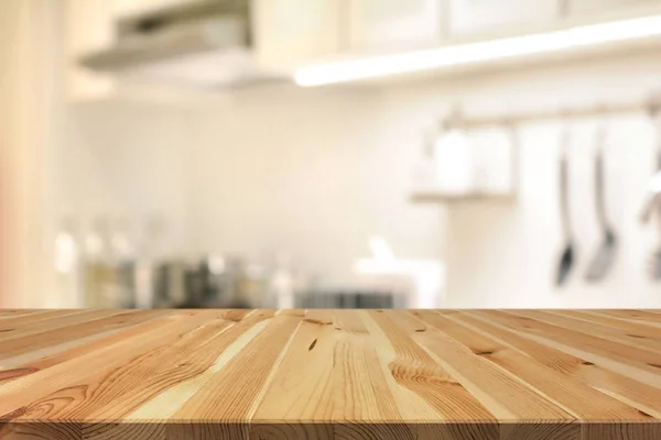 Wood table top (as kitchen island) on blur kitchen interior background