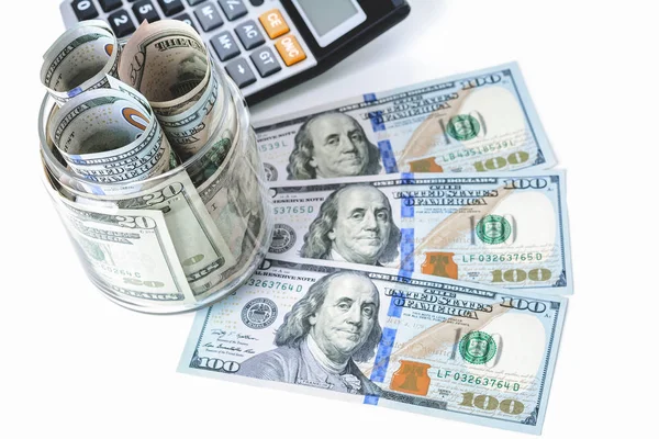 Dinero, billetes en dólares estadounidenses, con calculadora sobre mesa blanca —  Fotos de Stock
