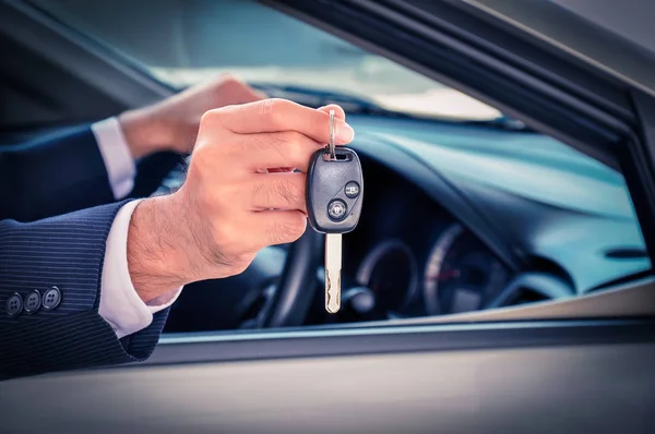 Podnikatel ruku ukazující klíč od auta — Stock fotografie