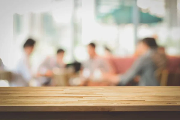 Tampo da mesa de madeira no fundo borrão das pessoas no café — Fotografia de Stock