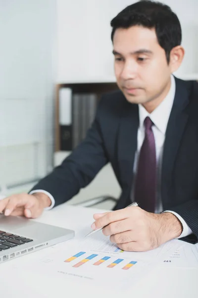 Knappe Aziatische zakenman, werkzaam in de kantoor met laptop — Stockfoto