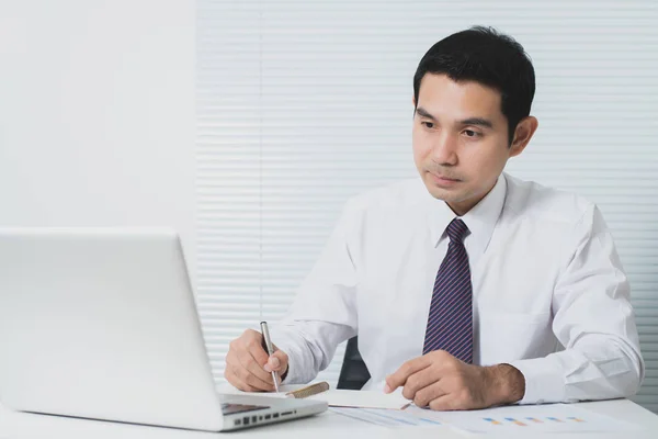 Knappe Aziatische zakenman, werkzaam in de kantoor met laptop — Stockfoto