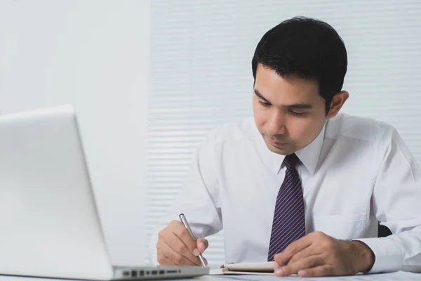 Knappe Aziatische zakenman werken serieus in het kantoor met laptop op tafel — Stockfoto