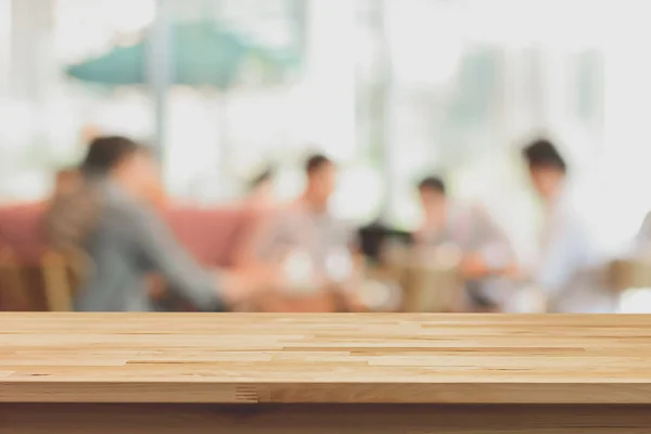 Mesa de madera sobre fondo borroso de personas en la cafetería —  Fotos de Stock