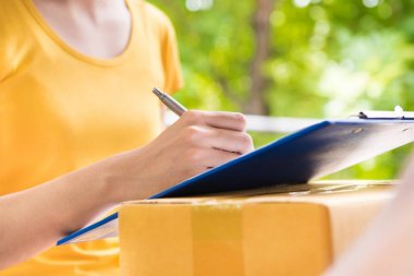 Genç kadın paketi alınırken belge imzalama