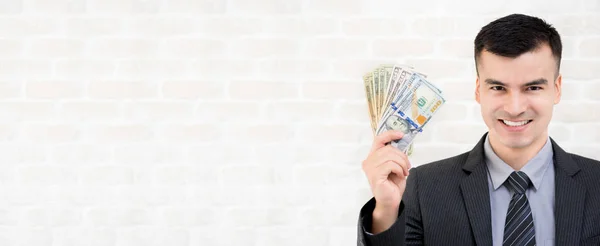 Junger lächelnder Geschäftsmann zeigt uns Dollargeld — Stockfoto