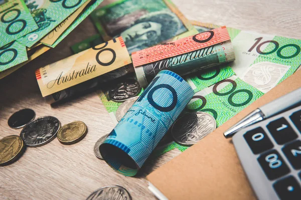 Pengar, australiensiska dollar (Aud), med bärbar dator och kalkylator på bordet — Stockfoto