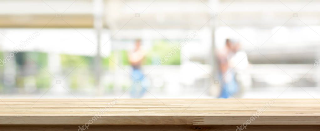 Wood table top on blur abstract background from outdoor covered walkway in the city,