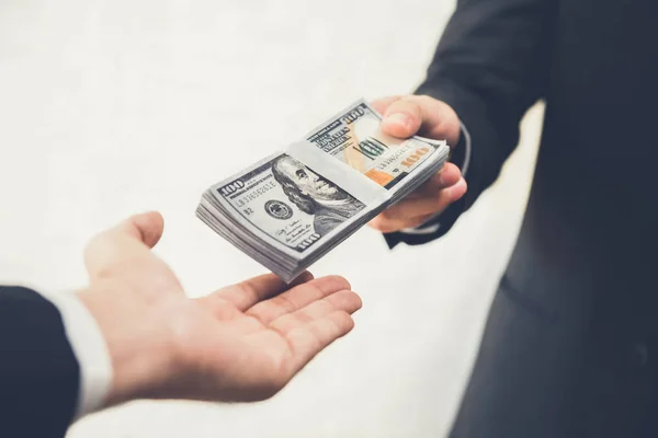 Empresário dando ou pagando dinheiro a um homem — Fotografia de Stock