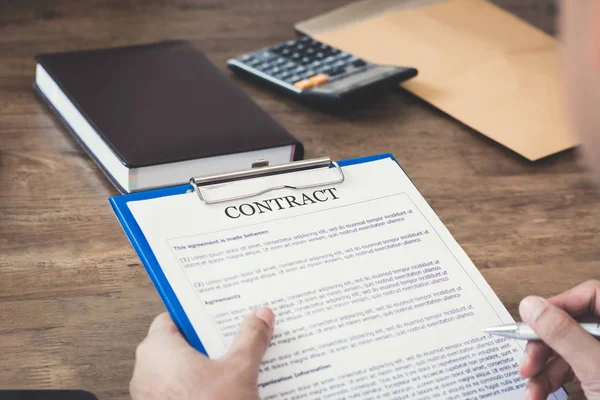 Een man die leest contract papier ongeveer te ondertekenen — Stockfoto