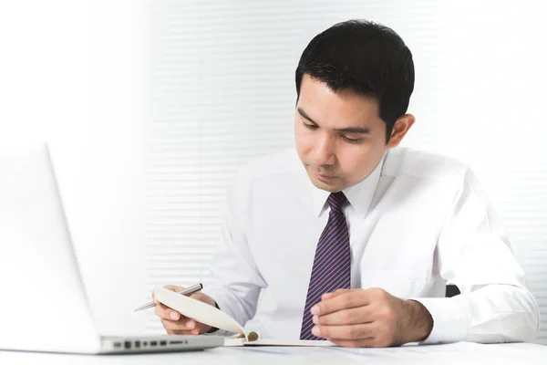Aziatische zakenman werken serieus in het kantoor met laptop op tafel — Stockfoto