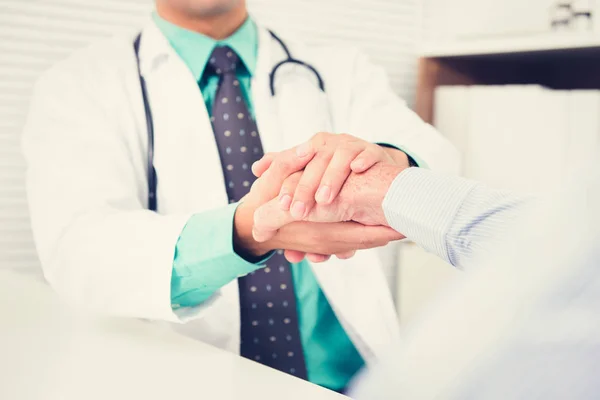 Doctor holding senior male patient hand with care — Stock Photo, Image