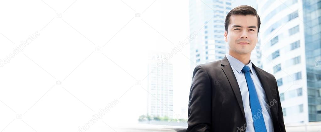 Handsome hispanic businessman standing on blur office building background