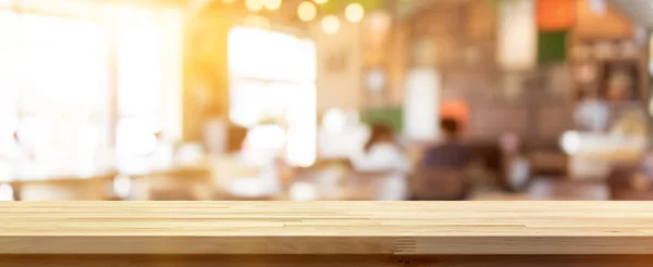 Meja kayu di atas blur coffee shop (kafe) latar belakang interior — Stok Foto