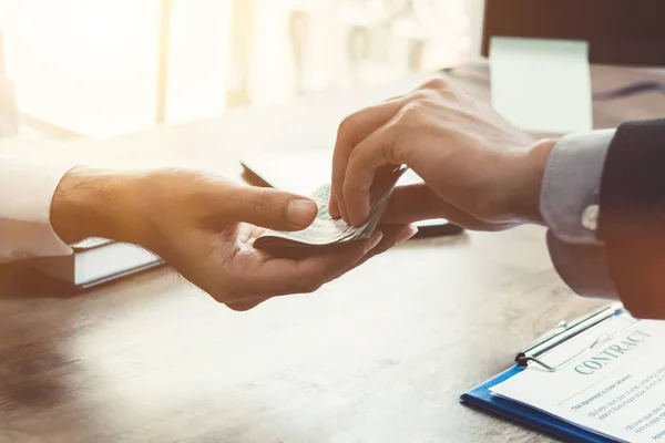 Affärsman som ger pengar till hans partner samtidigt kontrakt — Stockfoto