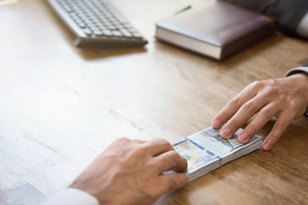 Zakenlieden geld doorgeven werktafel — Stockfoto