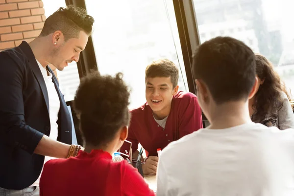 Jóvenes empresarios multiétnicos casuales prestando atención a su amigo en la reunión — Foto de Stock