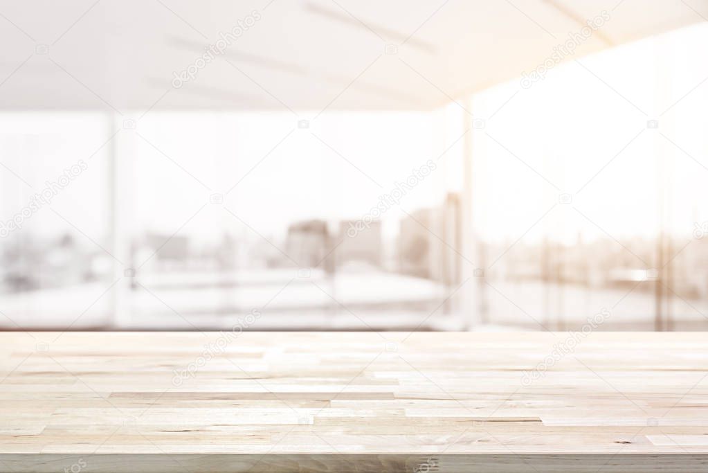 Wood table top in blur empty white office room with glass wall and city building view in background
