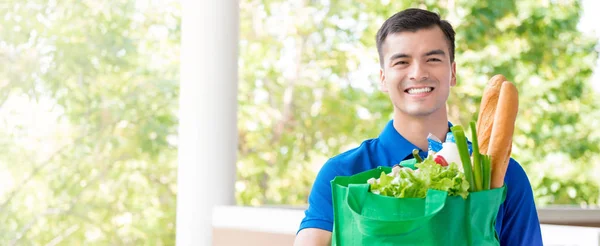 Sonriente hombre de entrega que reciclar bolso de compras de supermercado con alimentos dentro —  Fotos de Stock