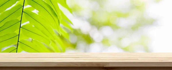 Trä bordsskiva på gröna naturliga ormbunke lämna banner bakgrund — Stockfoto