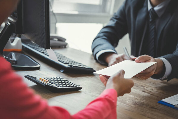 Бизнесмен получает деньги в конверте от женщины на работе
