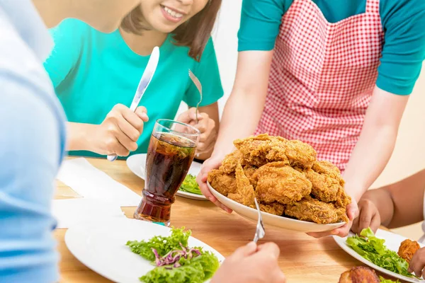 Grupo de jóvenes en mesa de comedor listos para comer pollo frito servido por el camarero en el restaurante — Foto de Stock