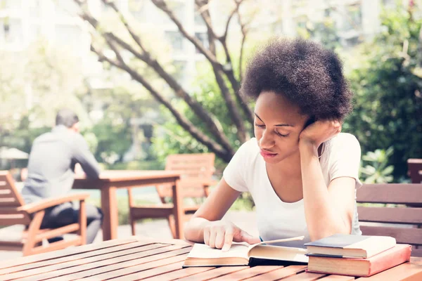 Afro college student reading book in the garden — Stock Photo, Image