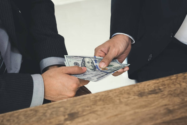 Businessmen secretly passing money to his partner 