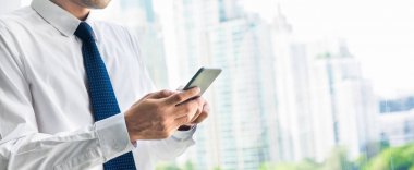 Ofis pencere TH Binası yanında Smartphone kullanarak iş adamı