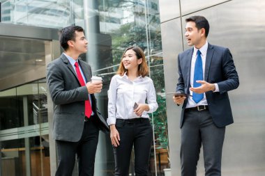 Yürüyüş ve ofis binası önünde konuşurken iş adamları