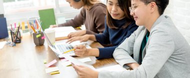 Çalışma odasında dizüstü bilgisayara bakan bir grup üniversite öğrencisi - kazanmak ve başarı kavramları