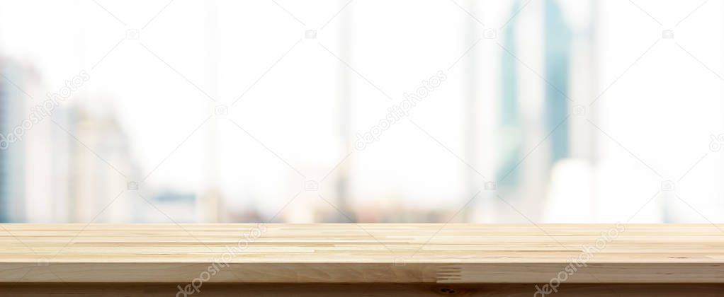 Wood table top on blur  city building view background looking th