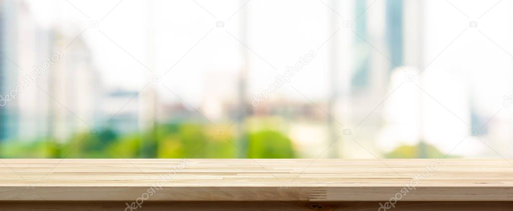 Wood table top on blur  city building view background looking th