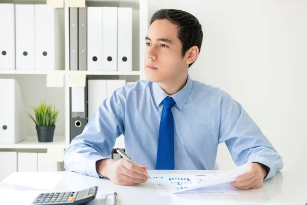 Jonge zakenman uitkijken en denken zittend op het werk — Stockfoto