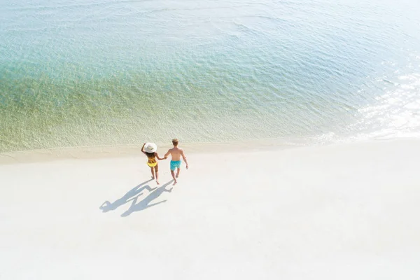 カップルがビーチで海水の中を歩く バードアイビュー — ストック写真