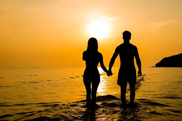 Σιλουέτα του ζευγάρι στην παραλία στο ηλιοβασίλεμα — Φωτογραφία Αρχείου