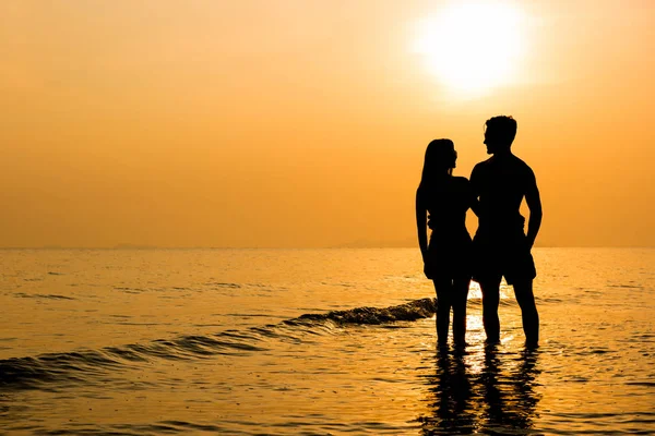 Silhouette eines schönen Paares am Strand bei Sonnenuntergang — Stockfoto