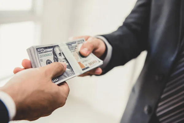 Empresario dando dinero, billetes de dólar, a su socio —  Fotos de Stock