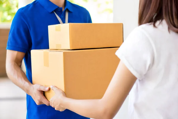 Deliveryman giving parcel box to a woman