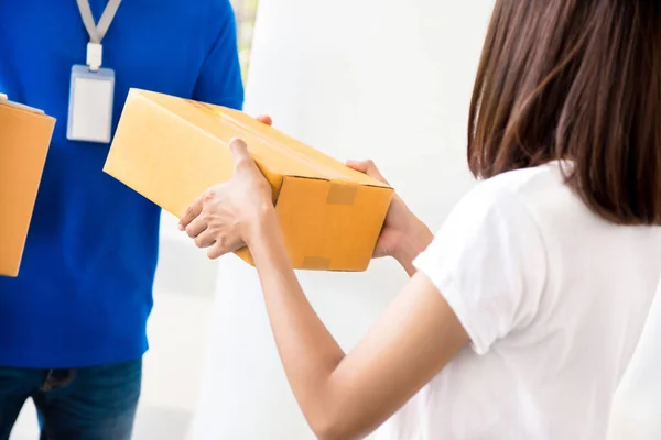 Entregador dando caja de paquetes a una mujer —  Fotos de Stock