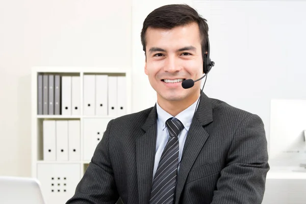 Bonito empresário sorrindo usando fone de ouvido microfone — Fotografia de Stock