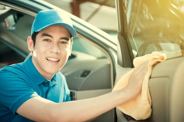 Smiling auto service staff cleaning car door — Stok Foto