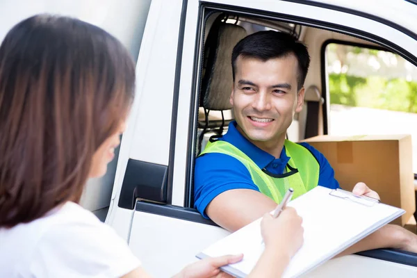 Leverans mannen i bilen att leverera paketet till en kvinna och ger — Stockfoto