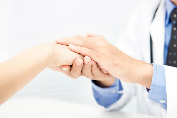 医師の注意を払って、患者の手を握ってな慰めを与える — ストック写真