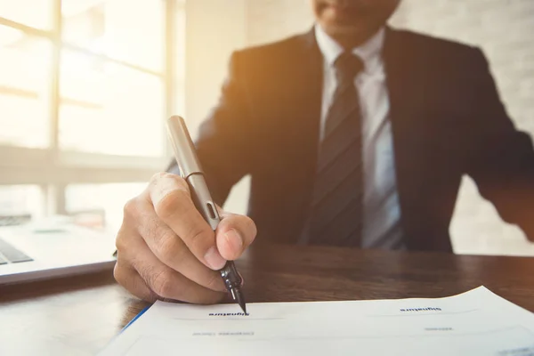 Zakenman ondertekenen contract document aan de tafel in het kantoor — Stockfoto